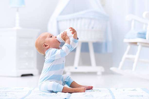 Baby drinks warm milk, bottle warmer