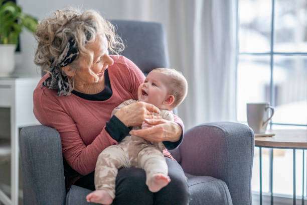 A beautiful grandma spending quality time with her 5-month-old granddaughter. bottle warmer